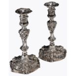 A pair of George II rococo silver candlesticks, cast and chased in high relief with masks,