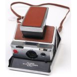 A Polaroid SX-70 Alpha 1 camera, silver and tan model, with styrofoam box Untested, sold as seen