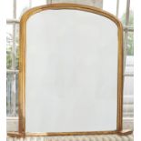A Victorian giltwood  over mantel mirror, late 19th c, the unbevelled plate in low arched and