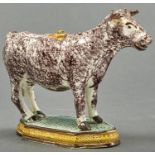 A Pratt ware cow creamer and a cover, early 19th c, sponged in manganese on shaped green and ochre