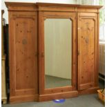 An Edwardian breakfront stripped pine wardrobe, with neo classical style composition applied