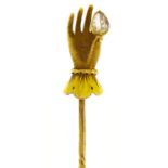 A stick pin, 19th c, the gold terminal in the form of a lady's hand holding a pear shaped diamond