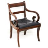 An early Victorian mahogany elbow chair, c1840, on sabre legs with black leather padded slip seat,