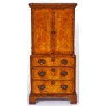 A walnut cabinet, 1980's, in George II style, enclosed by a pair of feather banded doors above