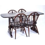 An Ercol elm dining table and set of four chairs, modern, the rounded rectangular top above