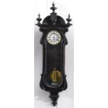 A Continental ebonised wall clock, late 19th c, the flared cornice with arched pediment centred on a