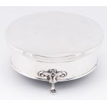 A George V round silver trinket box, on three hoof feet, 12.5cm diam, by William Neale Ltd,