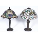 Two Tiffany style table lamps, the coloured glass shades decorated with roses and dragonfly's,