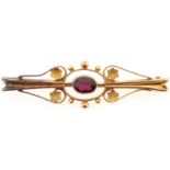 A gold bar brooch set with a garnet, marked 9ct, 2.8g