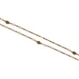 A gold long chain, early 20th c, of long and short links with 'knots' at intervals, 140cm l,
