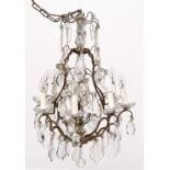 A Continental brass and cut and moulded glass chandelier, mid 20th c, of eight lights with moulded