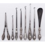Six silver handled button hooks and a pair of silver handled glove stretchers, various makers and