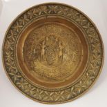 A Nuremberg brass alms dish, late 17th c, the slightly convex centre worked with grape harvesters in