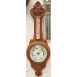 An Edwardian carved oak aneroid barometer, c1900, with mercury thermometer, 87cm h