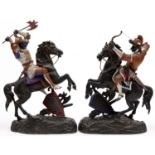 A pair of cold painted spelter figures of medieval warriors on rearing horses, one with axe, the