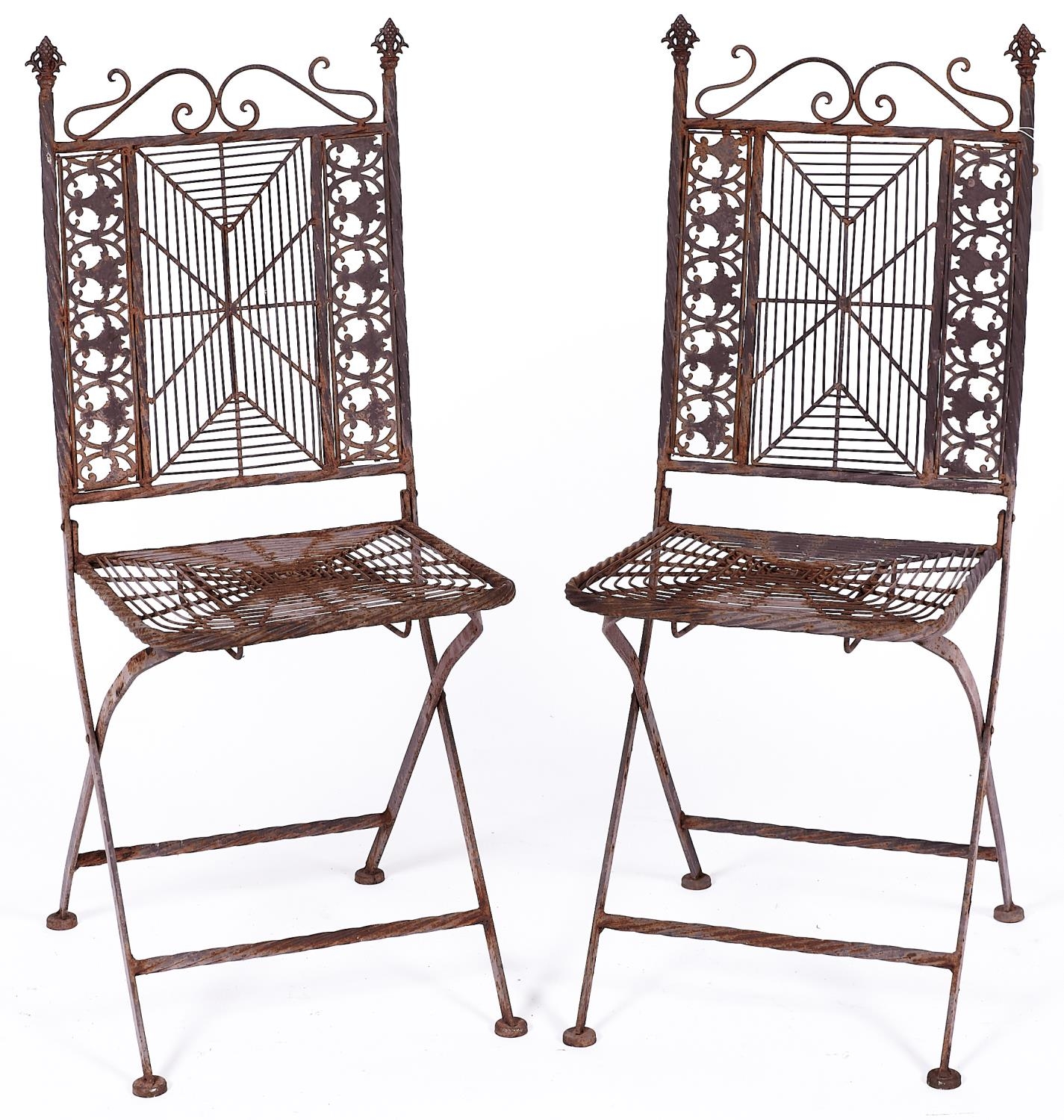 A pair of cast metal garden chairs, the ornate s-scroll top rails above spider's web splats