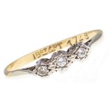 A three stone diamond ring, in gold marked 18ct & PT, 1.8g, size M Hoop distorted