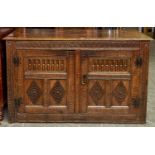 An oak  cupboard, 19th c,  with leaf carved frieze and carved three panel doors with H hinges, on