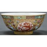 A Chinese yellow ground porcelain bowl, painted in iron red and gilt with dragon roundels, 15.5cm d,