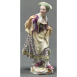 A Thuringian porcelain figure of a woman, 19th c, in puce bodice, striped skirt, yellow apron and