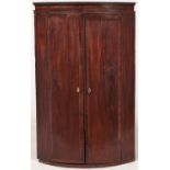 A George III bow fronted mahogany and line inlaid hanging corner cabinet, 69cm l Interior painted