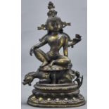 A bronze sculpture of Avalokiteshvara of the Lion's Roar, seated on an oval dais on the back of