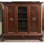 A Northern European carved walnut bookcase, 20th c, with dentil cornice and foliate carved frieze,