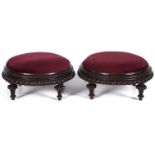 A pair of Victorian walnut circular footstools, c1870, with inset claret draylon tops with spreading