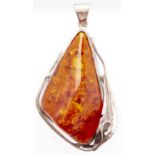 An asymmetrical amber pendant, mounted in silver