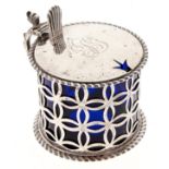 An Edwardian diaper pierced silver mustard pot, with grotesque handle and gadrooned rims, blue glass