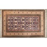 A modern Caucasian coloured bordered rug, the indigo field worked with stylised flowerheads and leaf