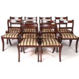 A set of ten Regency style mahogany dining chairs on sabre legs, green striped slip seats, seat