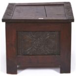 A small oak blanket chest, the hinged top panelled with carved borders, the front with panel