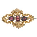 A Victorian garnet brooch, c1870, in gold, formed of c scrolls and leafage, 55mm l, 10.6g A good