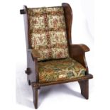 A barrel back winged chair with pegged top rail, second quarter 20th c , the panelled and boarded