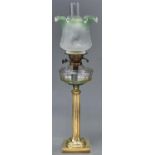 An Edwardian brass oil lamp, with faceted glass fount and brass burner, etched green shaded glass