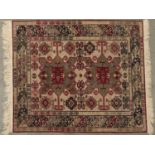 A Caucasian multi coloured bordered small rug, the ivory field with two barbed medallions in grey,
