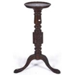 A mahogany tripod torchere, the dished circular top with bead carved rim, fluted turned column above