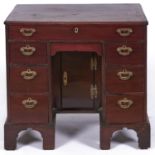 A George III mahogany kneehole desk or dressing table, late 18th c, with moulded top and fitted