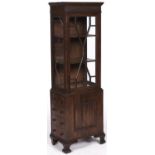 An oak display cabinet, early 20th c, with blind fret carved frieze, on associated mahogany drawer