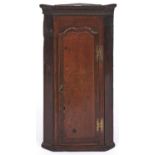 A splay fronted oak hanging corner cabinet, 76cm h; 26 x 41cm Reconstructed from early 19th c