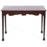 A mahogany side table, the rectangular top with moulded lip above a figured shaped frieze on