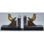 A pair of Art Deco patinated bronze mounted marble book ends, c1930, in the form of a dove on a