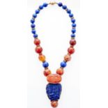 A Chinese carved lapis lazuli and cornelian pendant, the integral necklet of lapis lazuli and