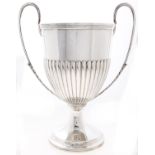 A Victorian silver cup, shield shaped with reeded rim and handles issuing from acanthus leaves, 36cm