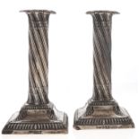A pair of Victorian dwarf silver columnar candlesticks, spirally fluted on square gadrooned foot,