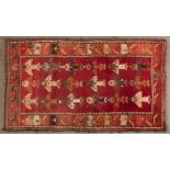 A modern Caucasian multi-coloured bordered rug, the shaded red ground worked with three rows of