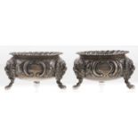 A pair of Victorian silver salt cellars, chased with flowers, on three lion mask and paw feet,