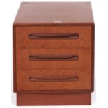 A G Plan teak small chest of three short drawers, inset skirted plinth and contrasting handles,