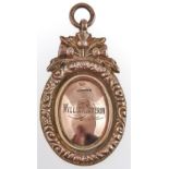 An oval 9ct gold prize watch fob shield, surmounted by thistles, with contemporary engraved